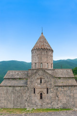 Fototapeta premium Surb Pogos-Petros Cathedral, Tatev Monastery - Armenian Apostolic Monastery of IX century. Mountains, green hills and clear blue sky. Armenia. 