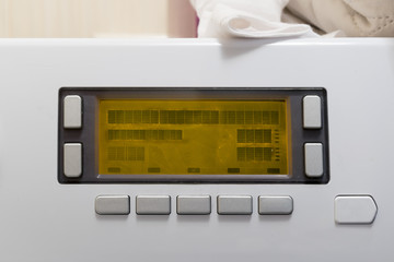 Closeup of new white washing machine control panel with display and buttons.