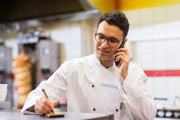 chef at kebab shop calling on smartphone