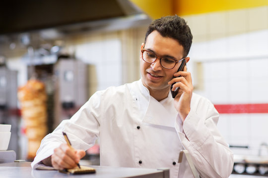 chef at kebab shop calling on smartphone