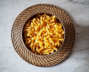 Fusilli, a type of pasta from South Italy, in a bowl on a straw round tray