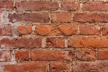 old wall of weathered   bricks with cracks closeup