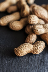 Dried peanuts in shell on black background, selective focus