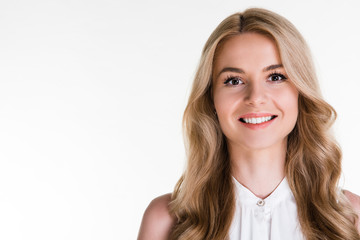 Cheerful smile. Portrait of beautiful young woman looking at camera with smile while standing against white background