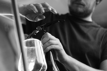 Man closing an home made wine bottle. Black and white, detail.