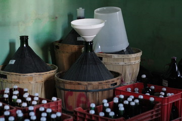 Demijohns Carboys and bottles in home wine cellar.