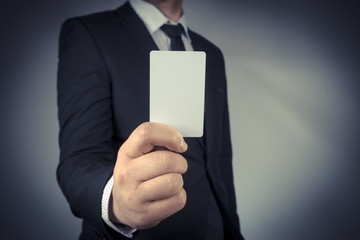 Businessman holding a blank gold business card in his hand