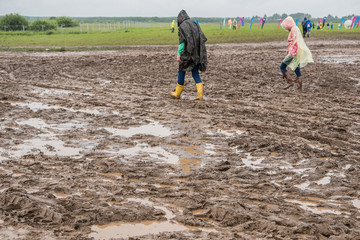 In rubber boots on dirt, at the festival