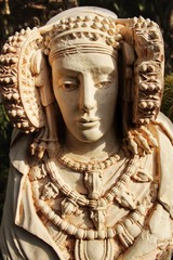 Lady of Elche bust in a garden under the sun