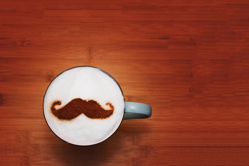 cup of cappuccino with cinnamon art in the shape of a mustache 