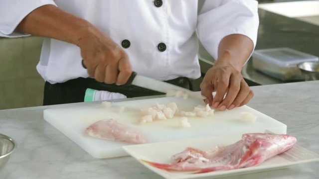 Chef cutting fish in the restaurant kitchen, proffesional cooking