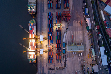 Containers yard in port congestion with ship vessels are loading and discharging operations of the transportation in international port.Shot from drone.