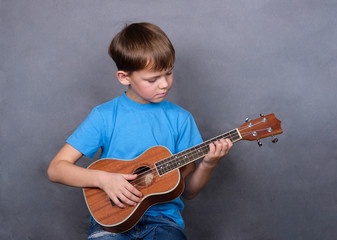 European boy playing ukulele