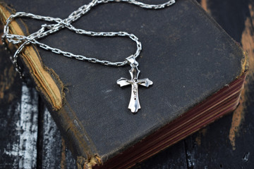 Fototapeta na wymiar silver cross lies on the old holy bible