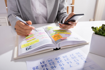 Person Hands With Mobile Phone And List Of Work