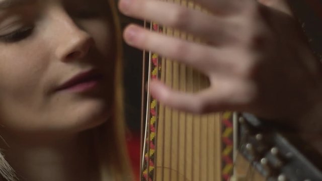 Young Ukrainian woman plays a traditional bandura instrument, refocus