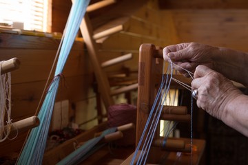 Senior woman weaving silk at shop