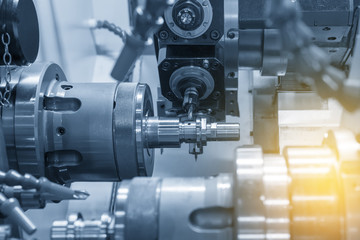 The  CNC lathe milling the steel shaft .The  modern machining process.