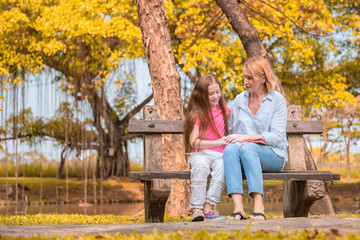 Naklejka premium Mom and daughter are sitting in the park. Soft focus concept.