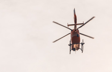 Red flying helicopter at sunset