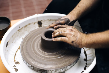 Artist makes clay pottery on a spin wheel
