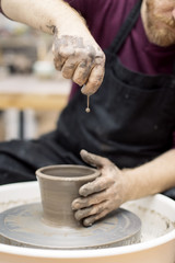 Artist makes clay pottery on a spin wheel