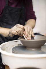 Artist makes clay pottery on a spin wheel