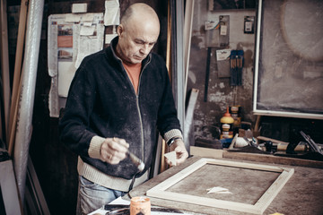 The carpenter makes frames.