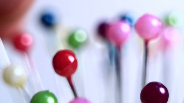 Tools tailor. Many multi-colored pins close-up. Shallow depth of field. Smooth rotation and impact.