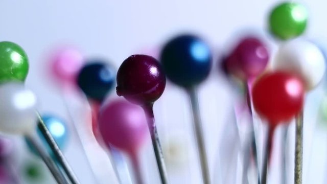 Tools tailor. Many multi-colored pins close-up. Shallow depth of field. Smooth rotation and impact.