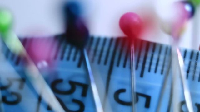 Tools tailor. Many multi-colored pins close-up. Shallow depth of field. Smooth rotation and impact.