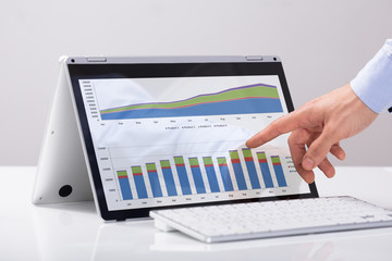 Businessman Pointing On The Chart Over Hybrid Laptop Screen