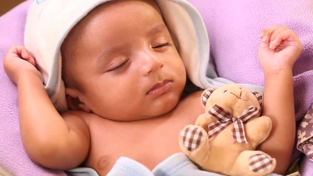 Teddy bear with sleeping newborn baby boy 
