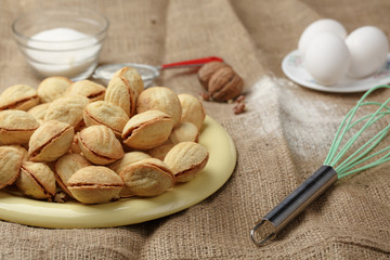 homemade cookies shaped nuts with cream boiled condensed milk on wooden table. Rustic style