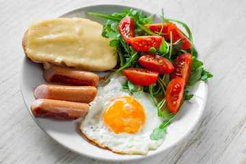 Breakfast which includes eggs, sausages, salad and toast with cheese