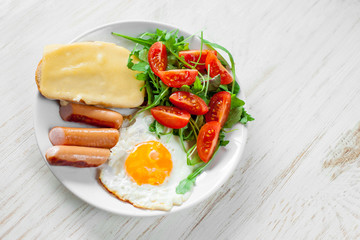 Breakfast which includes eggs, sausages, salad and toast with cheese
