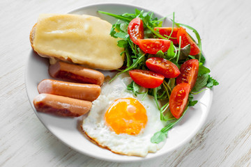 Breakfast which includes eggs, sausages, salad and toast with cheese