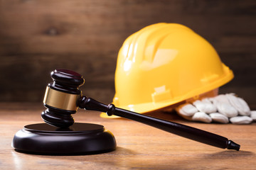 Gavel In Front Of Yellow Safety Helmet