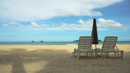 Fototapeta na wymiar Beach with deck chairs, sun beds, umbrellas. Beach, sea, sand,wave. Seascape ocean and beautiful beach paradise, blue sky, clouds. Philippines El Nido Travel concept