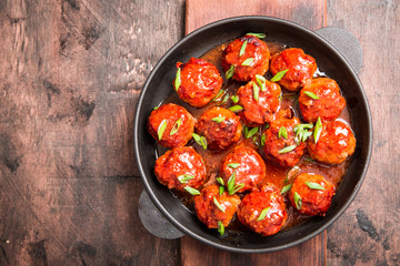 Meatballs in sweet and sour tomato sauce. Homemade roasted beef meatballs in cast-iron skillet