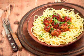 Spaghetti pasta meatballs with tomato sauce, herbs on wooden background