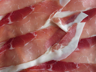 Rustic ham prosciutto as background . Fresh cold cuts from Tuscany, Italy
