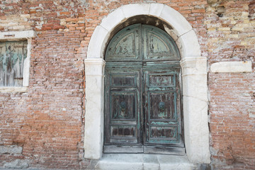 Fototapeta na wymiar antique large decorative wooden door in a brick building