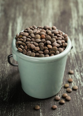 Ceramic bowl with red lentils on wooden background. Vertical Healthy food.