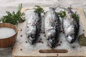 Salted mackerel on a cutting board with spices
