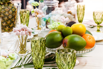 Festive table, decorated with vases, fruits and pastries.