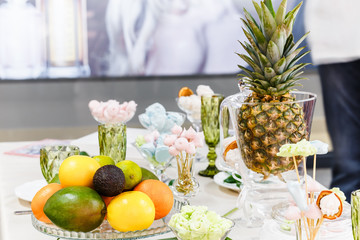 Festive table, decorated with vases, fruits and pastries.