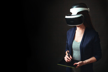 Girl in VR glasses of virtual reality with gamepad playing game. Young girl in virtual augmented reality helmet. VR headset. Future technology concept. Testing the application in vr