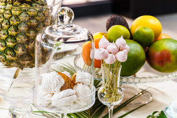 Festive table, decorated with vases, fruits and pastries.