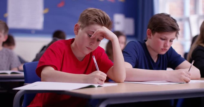 4k, A young student struggling during a class test. Slow motion.